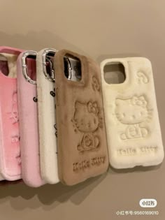 hello kitty phone cases are lined up in a row on the wall, one is pink and one is white