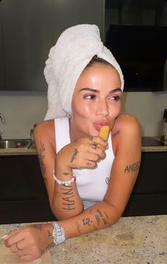 a woman with tattoos on her arms eating food