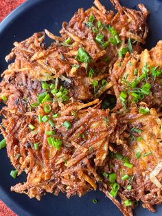 fried food on a blue plate with green onions and seasoning sprinkled around it