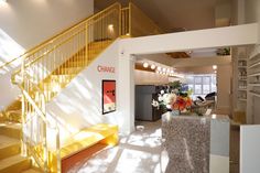 a yellow staircase leading up to a living room with white walls and carpeted flooring