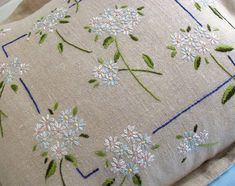 an embroidered pillow with daisies on it