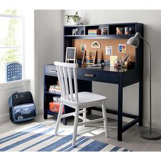 a desk with a chair, bookshelf and pictures on the shelf in front of it