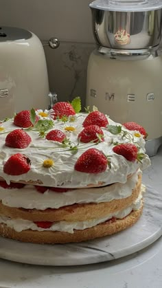 a cake sitting on top of a white plate covered in frosting and strawberries