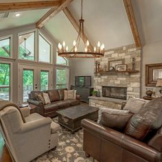 a living room with couches, chairs and a fire place in front of a fireplace