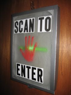 a sign that says scan to enter with a hand print on the back of it