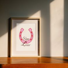 there is a picture frame with a pink horseshoe on it