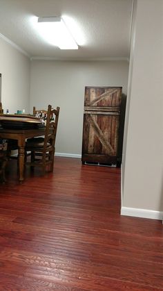 a dining room with hard wood flooring and an open door leading to the kitchen