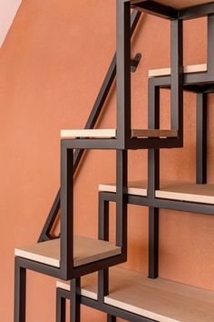 a set of stairs made out of wood and metal with wooden shelves on each side