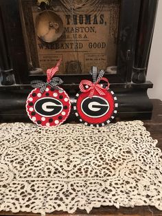 two red and black polka dot ladybug christmas ornaments sitting on top of a doily