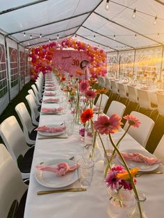 a table set up with plates and flowers in vases on top of the tables