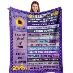 a woman holding up a purple blanket with sunflowers on it and the words you are