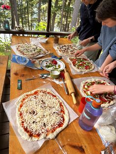 children making homemade pizzas on a picnic table