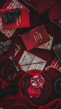 a table topped with books and other items on top of a red cloth covered floor