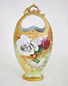 an ornate vase with flowers painted on the outside and gold trimming around the top