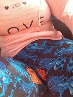 a woman sitting on a couch wearing leggings and a t - shirt that says love