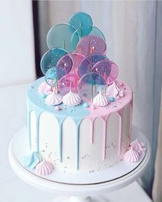 there is a cake decorated with pink, blue and white icing