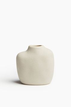 a white vase sitting on top of a table