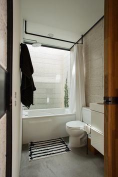 a white toilet sitting next to a bath tub