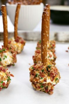 small appetizers are lined up on a table with dip sticks sticking out of them