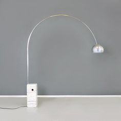 a lamp that is sitting on top of a table in front of a gray wall