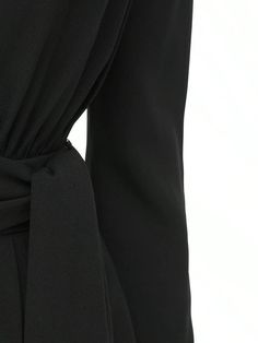 Deep V neckline. Long sleeves. Padded shoulders. Concealed back hook and zip closure. Includes matching belt. Fitted waist. Two side pockets. Lined. Model is wearing a size36 Elegant Belted Jumpsuits And Rompers, Evening Fitted Jumpsuits And Rompers With Tie Waist, Chic Jumpsuits And Rompers With Belt For Workwear, Elegant Jumpsuits With Belted Cuffs, Elegant Fitted Jumpsuit With Back Zipper, Elegant Fitted Jumpsuits And Rompers With Back Zipper, Fitted Elegant Jumpsuits And Rompers With Back Zipper, Elegant Long Sleeve Jumpsuits And Rompers With Tie Waist, Formal Black Belted Jumpsuit