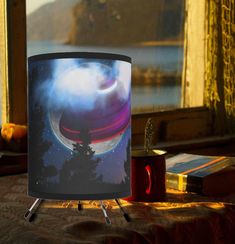 a lamp shade sitting on top of a table next to a book and some books