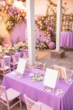 a purple table with white chairs and tables covered in cards, magnets and decorations