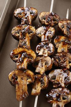 mushrooms on skewers are sitting on a tray