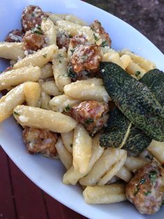 a white bowl filled with pasta and meat