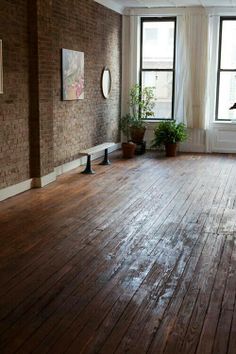 an empty room with wooden floors and large windows