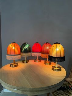 four lamps sitting on top of a wooden table