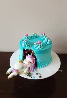 there is a blue cake with a unicorn on it