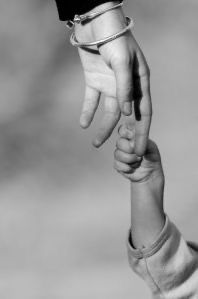 a black and white photo of two hands holding the hand of a child's hand