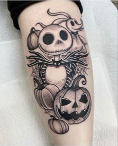 a person with a tattoo on their leg that has a cat and pumpkins in it