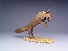 an origami fox is standing on its hind legs and has it's mouth open