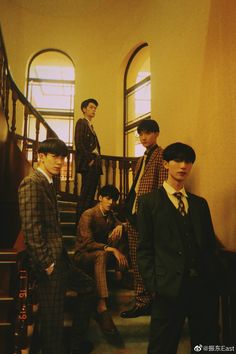 men in suits and ties are standing on the stairs