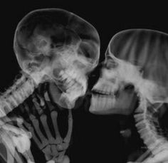 two skeletons kissing each other in black and white