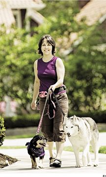 a woman walking two dogs on a leash