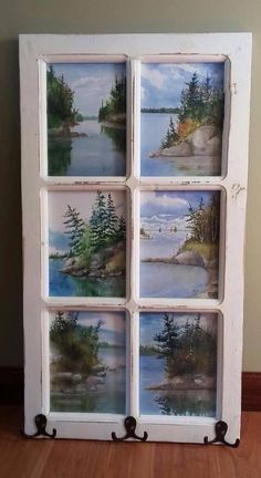 an old window is painted with pictures of trees and water on it's sides