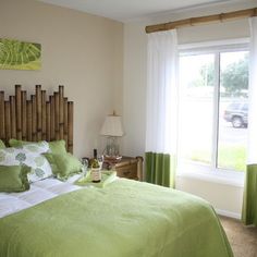 a bedroom with green bedding and white curtains