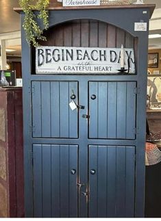 a blue cabinet with a sign that says begin each day