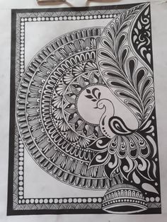 a black and white drawing on paper with scissors next to it, which has an intricate design in the middle