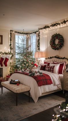 a bedroom decorated for christmas with red and white bedding, stockings, wreaths and lights