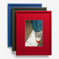 three different colored frames with a person's feet on the ground in front of them