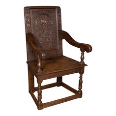 an old wooden chair with carvings on the back and arms, sitting against a white background