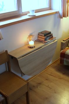 a living room filled with furniture and a table next to a chair in front of a window