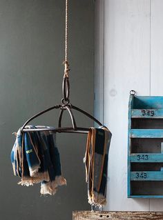 an old wooden crate hanging from a rope next to a blue and white painted wall