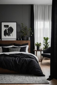 a bedroom with black and white bedding, plants and pictures on the wall above it