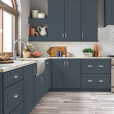 a kitchen with gray cabinets and tile flooring