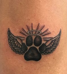 a dog's paw and angel wings tattoo on the back of a woman's stomach